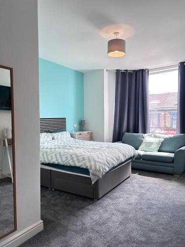 a bedroom with a bed and a couch and a mirror at Myrtle Villas in Hull