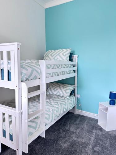 two bunk beds in a room with blue walls at Myrtle Villas in Hull