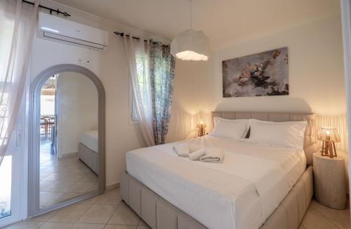 a bedroom with a white bed with two towels on it at Corfu Dream Apartment Chrysion in Glyfada