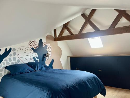 a bedroom with a blue bed with a blue comforter at l'Ocean in Dieppe
