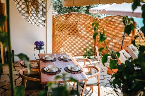 a table and chairs on a patio with plants at Corfu Dream Apartment Chrysion in Glyfada