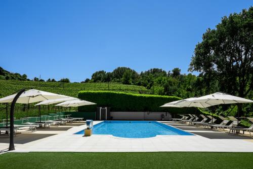 a swimming pool with chairs and umbrellas at Vigna Dell'Acqua in Santo Stefano Belbo