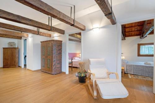 a living room with a chair and a bed at Cozy Country Loft Oleandro in Chioggia