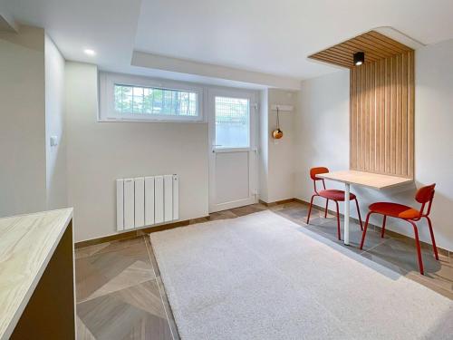 a dining room with a table and two red chairs at Proche Luxembourg et centrale Cattenom in Hettange-Grande