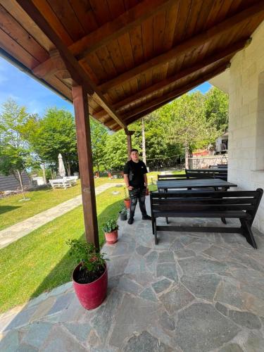a man standing under a pavilion with two benches at Razem Lendina e Qete in Razëm