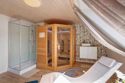 a room with a glass cabinet and a white chair at Haus Schnettler mit Sauna in Bestwig