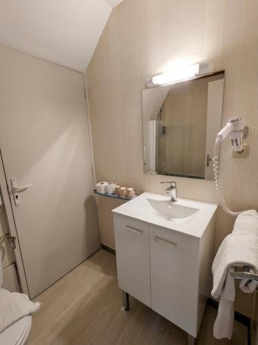 a bathroom with a white sink and a mirror at Brit Hotel Confort Deltour Mende in Mende
