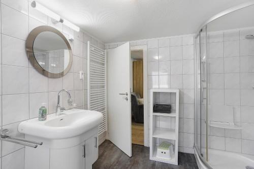 a white bathroom with a sink and a shower at Haus Schnettler mit Sauna in Bestwig