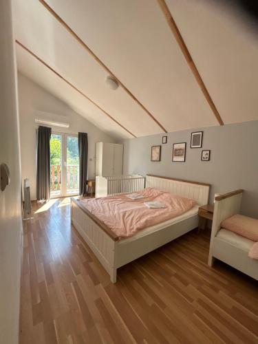 a bedroom with a large bed and a chair at Пе́трови Вили in Ribarica