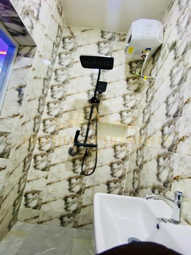 a bathroom with a sink and a hair dryer on the wall at Arithia Apartments in Mama