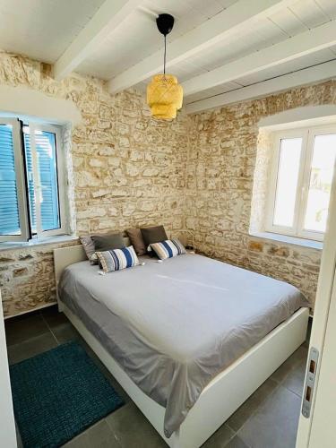 a bedroom with a large bed in a stone wall at Maison Bleu Katomeri in Katomérion