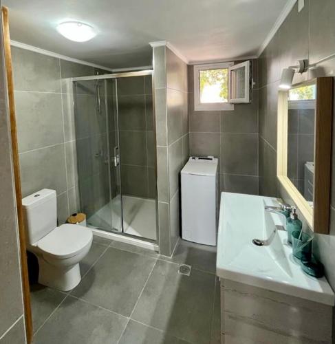 a bathroom with a toilet and a shower and a sink at Maison Bleu Katomeri in Katomérion