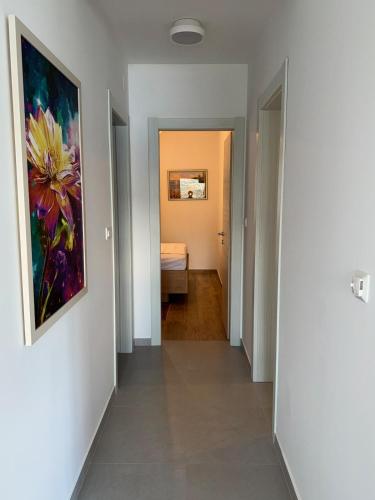a hallway with a painting on the wall and a bedroom at Luxury Apartment The Best in Cavtat