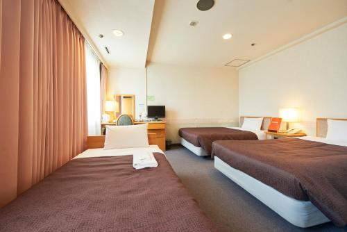 Ліжко або ліжка в номері Hotel Select Inn Aomori