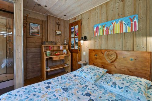 a bedroom with a bed and wooden walls at Chambre D'hôtes La Télécabine in La Balme-de-Thuy