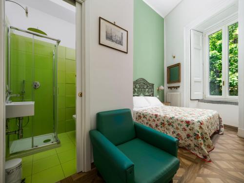 a bedroom with a bed and a shower and a green chair at De Vivo Realty - Coco's Apartments in Meta