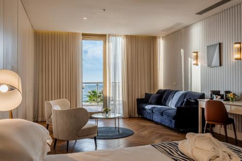 ein Hotelzimmer mit Sofa und Wohnzimmer in der Unterkunft Daniel Herzliya Hotel in Herzlia