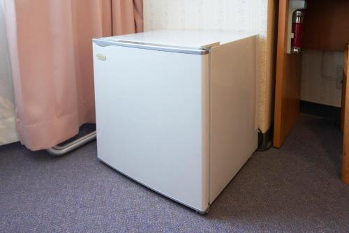 a small white refrigerator sitting in a room at Hotel Select Inn Aomori in Aomori