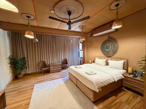 a bedroom with a bed and a ceiling fan at Aldar Inn - نزل الدار in Nizwa