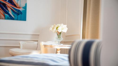 a vase of flowers on a table in a room at Boutique Charme Apartment Ricarda in Baden-Baden