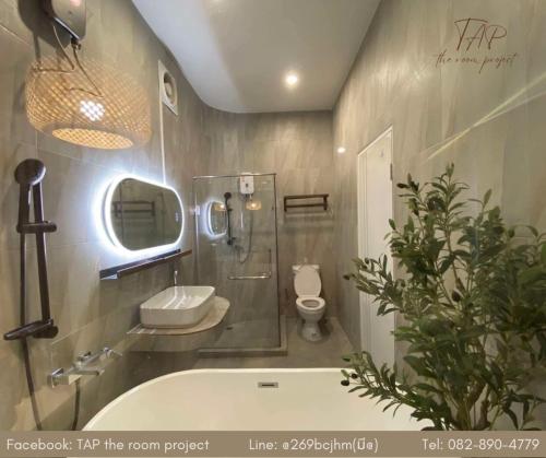 a bathroom with a tub and a toilet and a sink at TAP Salaya in Salaya