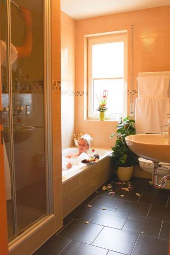 a child laying in a bath tub in a bathroom at Ferienpark Templin direkt neben der Naturtherme in Templin