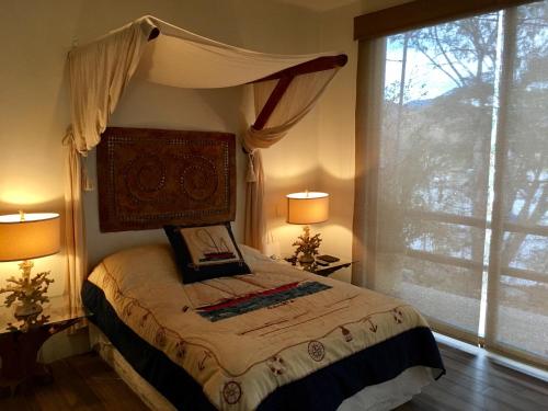 a bedroom with a bed with two lamps and a window at Casa Belmez in Valle de Bravo