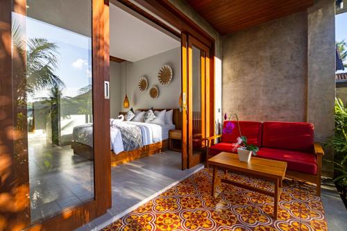 a bedroom with a bed and a red couch at The Dura Ubud in Ubud