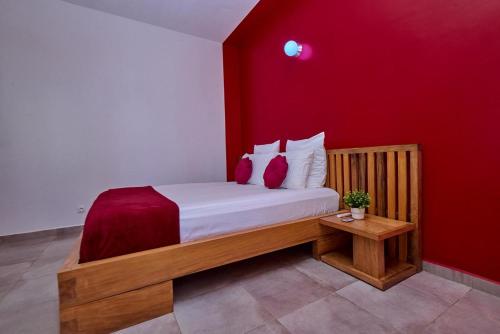 a bedroom with a bed with a red wall at Villa de détente "Tombosoa" avec vue sur la baie de Diego-Suarez in Antsiranana