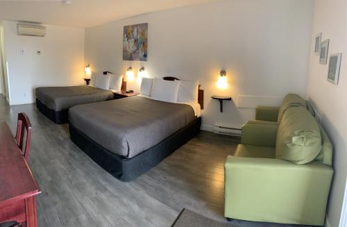 a hotel room with two beds and a couch at Complexe Hotelier Escoumins in Les Escoumins