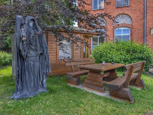 a statue of a nun next to a picnic table and a bench at Ferienwohnung Barbarossa - Holly in Rottleben