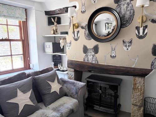 a living room with a fireplace and a mirror at Brewhouse Cottage 18th Century Cottage -Three Peaks Settle in Settle