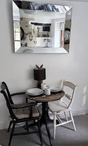 a table and chairs in a room with a mirror at Brewhouse Cottage 18th Century Cottage -Three Peaks Settle in Settle