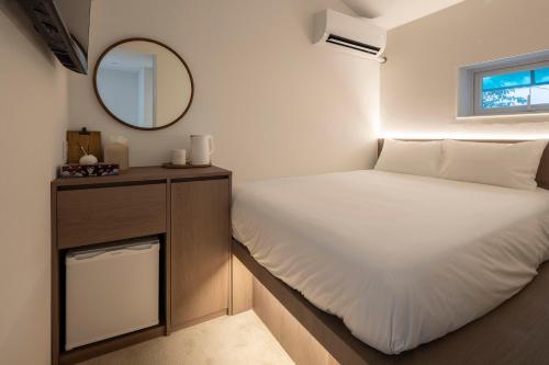 a small bedroom with a bed and a mirror at YUONJAE Jongno in Seoul