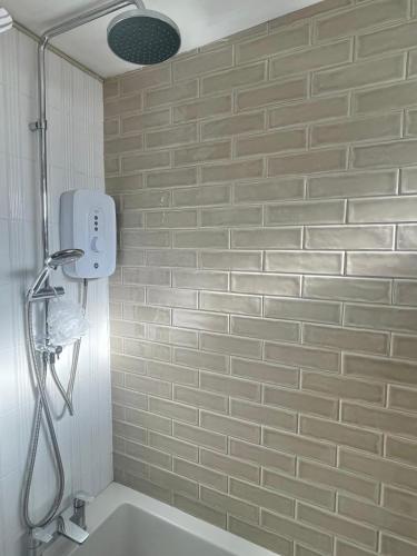 a bathroom with a shower and a bath tub at Alder House Lytham in Lytham St Annes
