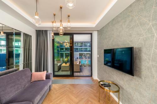 a living room with a couch and a tv at Apartament Bursztynowa Komnata 116 Stegna nad morzem in Stegna