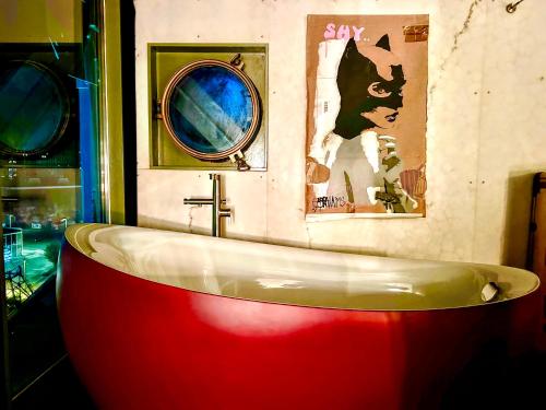 a bath tub in a bathroom with paintings on the wall at Faralda Crane Hotel in Amsterdam