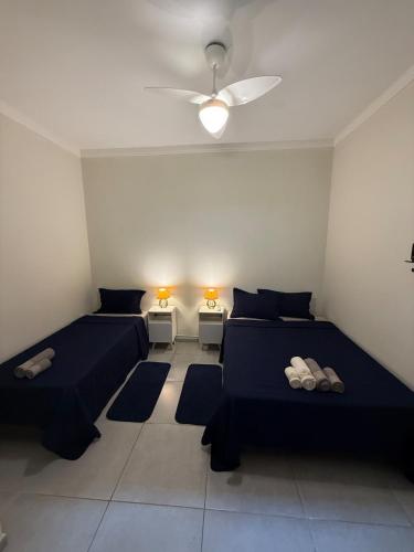 a room with two beds and a ceiling fan at Self check-in Garagem Ar 13 min ABQM in Araçatuba