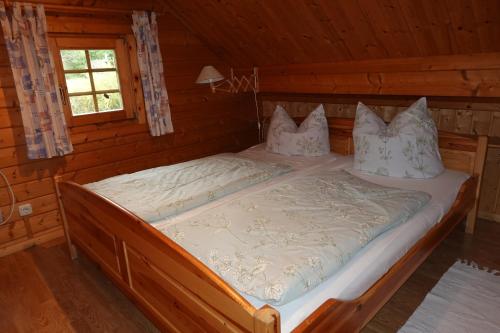 a bedroom with a bed in a log cabin at Ferienhaus Großmann in Drognitz