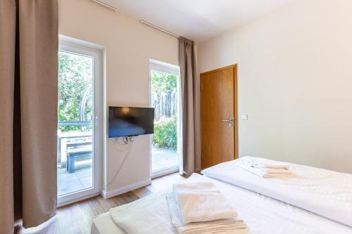 a bedroom with a bed and a tv and a window at Strandleben - Galerie Nummer 13 in Ahrenshoop