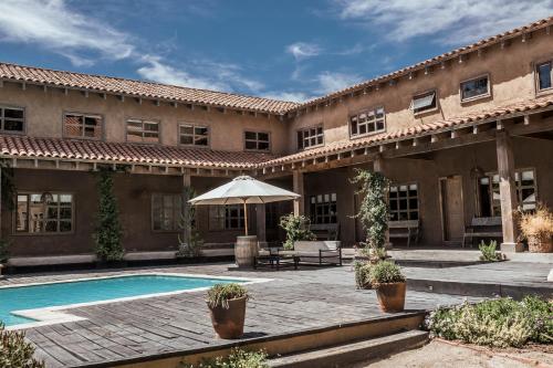 a building with a swimming pool and an umbrella at Casona el Refugio Casablanca in Casablanca