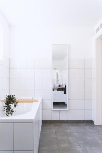 a white bathroom with a tub and a sink at Apartment 39 in Giengen an der Brenz