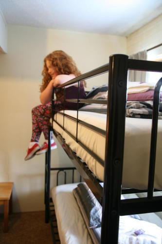 a girl is sitting on top of a bunk bed at Alpine Retreat Mt Buller in Mount Buller