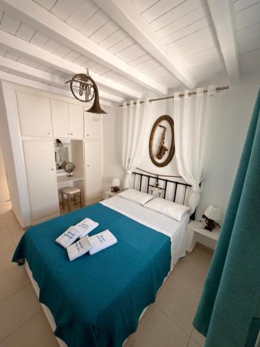 a bedroom with a bed with a blue blanket at Mykonos Secret Spot in Mikonos