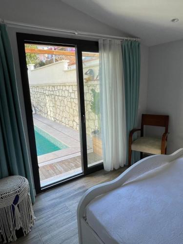 a bedroom with a bed and a view of a pool at Chloe hotel Alaçatı in Alaçatı