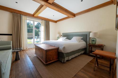a bedroom with a large bed and a window at Hostellerie De Levernois in Levernois