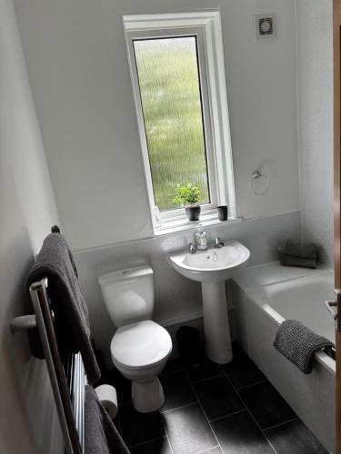 a bathroom with a toilet and a sink and a bath tub at Kilnhill in Hawick
