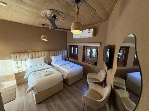 a room with two beds and a chair in it at Aldar Inn - نزل الدار in Nizwa