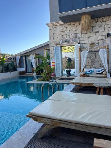 a bed sitting next to a swimming pool at Chloe hotel Alaçatı in Alaçatı