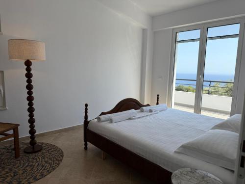 a bedroom with a bed with a view of the ocean at Roberts Villa in Dhërmi